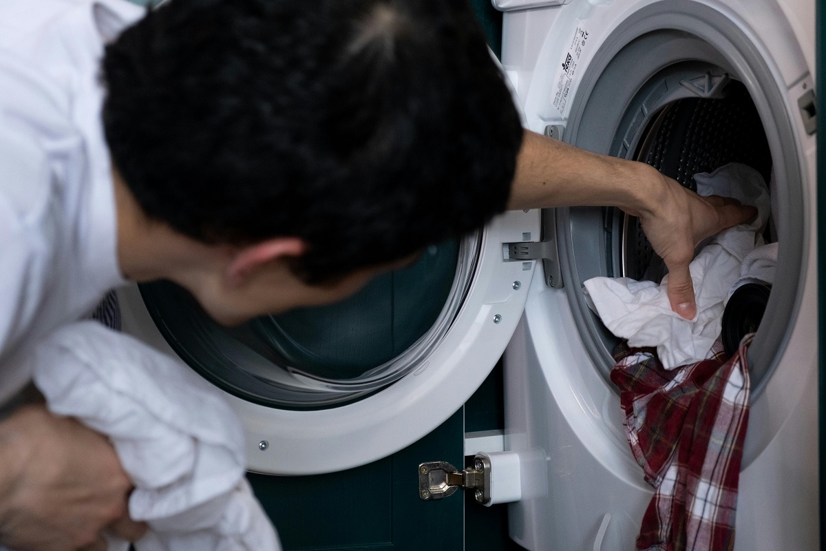 man taking laundry out of a washing machine
